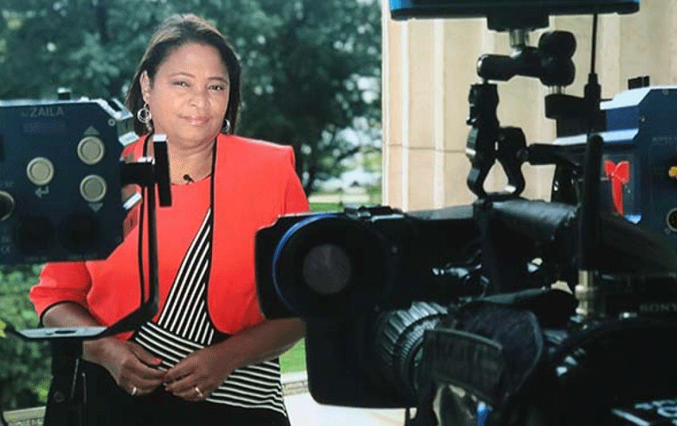 Reporter Lori Montenegro portrait with camera equipment in the foreground.